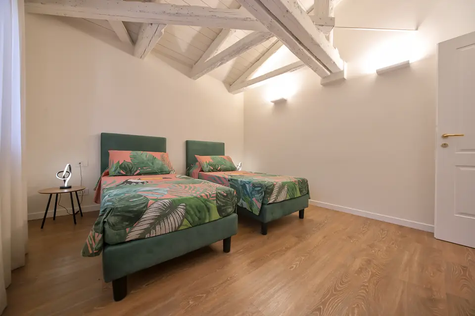 Dormitorio con dos camas y colchas de hojas tropicales