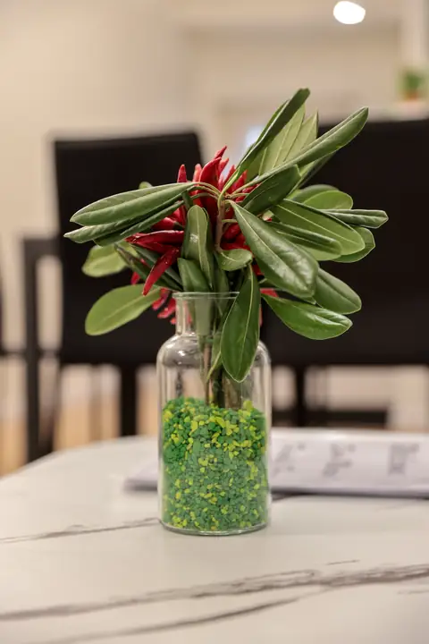 Un jarrón de flores en la mesa del salón