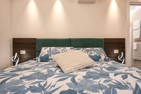 Cama doble con colcha de hojas azules