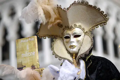 Máscara dorada de carnaval con un libro de Marco Polo