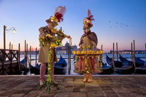 Dos disfraces de carnaval en la orilla al anochecer